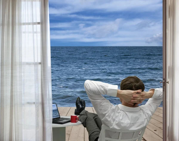 Расслабляющий бизнесмен и море — стоковое фото