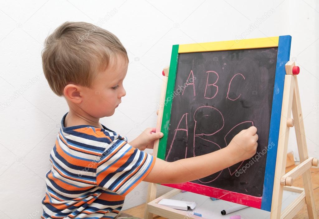 child writes the alphabet