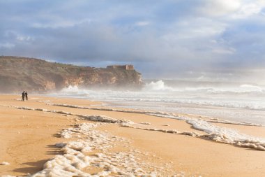 Atlantik Okyanusu kıyısında Portekiz Nazileri. Kıyı şeridi, dalga ve köpük. Kaçış ve yavaş yaşam konsepti. Sinematik deniz duvar kâğıdı, doğa manzarası arka planı. Manzara resmi