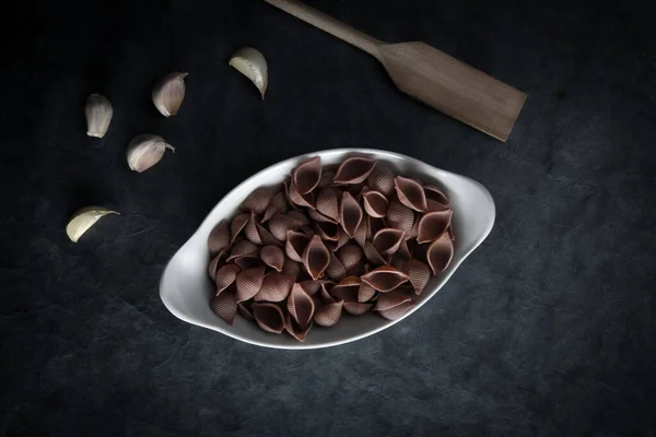 Koyu bir arkaplanı olan renkli bir makarna. Metin Boşluğu için ideal