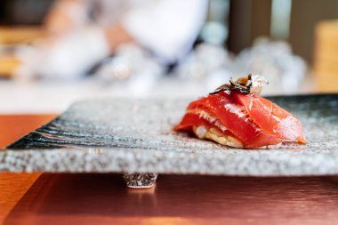 Japon Omakase yemeği: Yaşlanan Çiğ Akami Ton Balığı Suşi, dilimlenmiş trüf mantarı ile taş tabakta servis edilir. Japon geleneksel ve lüks yemeği.