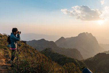 Macera fotoğrafçıları gün batımında Doi Luang Chiang Dao, Chiang Mai, Tayland 'da dağ ve manzaranın fotoğraflarını çekiyorlar. Dağın tepesinden almak.