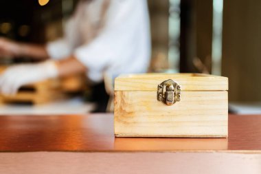 Japon Omakase yemeği: arka planda bulanık Omakase şefi olan gizli yiyeceklerle dolu ahşap bir kutunun önü. Kopyalama alanı olan resim.
