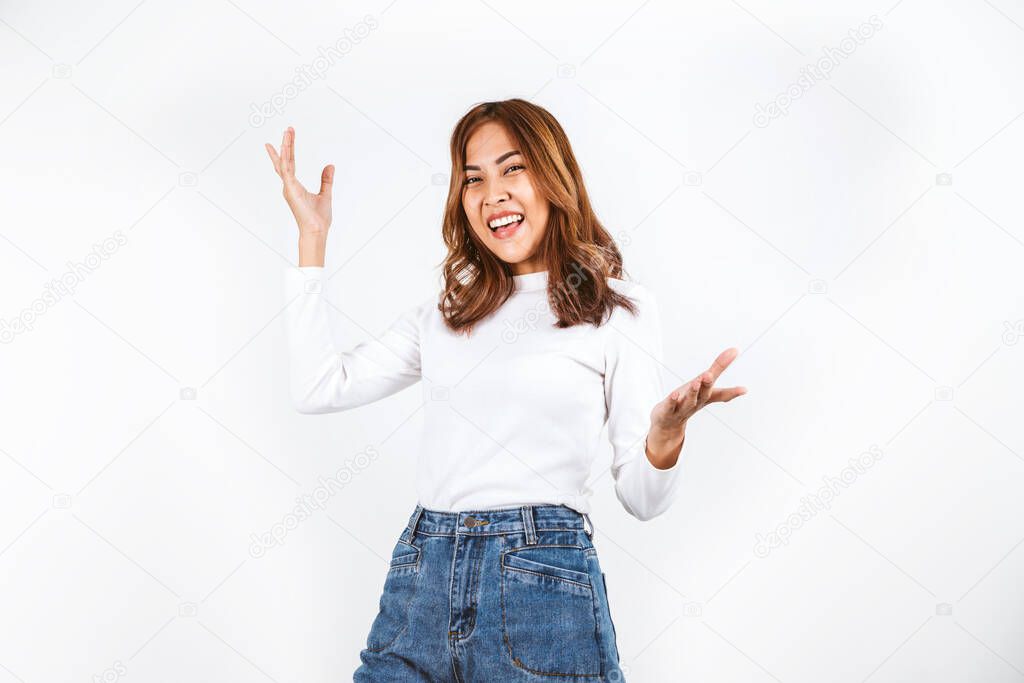 Asian dyed brown-haired girl in white sweater dancing with hands up and inspired face expression in white background.
