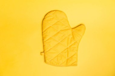 Top view of yellow oven gloves on yellow color background. Mockup for food banner and kitchen protection equipment. clipart