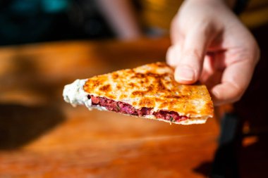 El ele tutuşan Vegan Quesadilla: Tzaziki soslu vegan peynirli tatlı patates ve kırmızı fasulyeyle dolu ızgara tam buğday tortilla. Yaratıcı Meksika vejetaryen yemekleri.