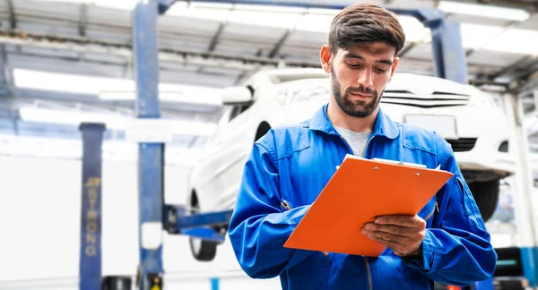 Mechaniker Blauer Arbeitskleidung Checken Die Checkliste Für Die Fahrzeugwartung Hintergrund — Stockfoto