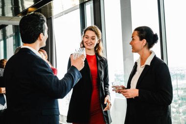 Kurumsal resepsiyonda üst düzey ofislerde içki içen resmi giyim şebekesindeki profesyoneller. Şehrin ufuk çizgisi çerçeveleri seminer tarzı işbirliği, satış, liderlik, ortaklık ve meslektaşlar.