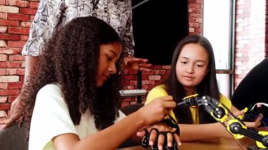 Mutlu çocuklar bir robotik sınıfında başarıyı kutluyorlar, BTMM kodlama projesini tamamladıktan sonra öğretmenlerine beşlik çakıyorlar. Eğitim teknolojisinde takım çalışması ve yenilik ruhuna sahip çeşitli gruplar.