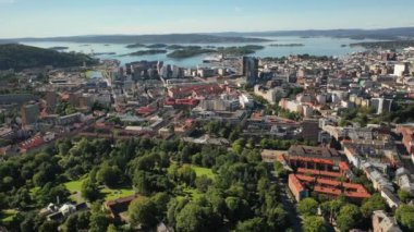 Oslo, Norveç. Hava aracından Oslo şehir merkezine güzel bir 4K panoramik hava görüntüsü. Güneşli bir yaz gününde denizin arka planında, dağlarda ve mavi gökyüzünde. (Seriler)
