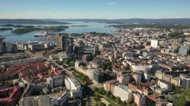 Oslo, Norveç. Hava aracından Oslo şehir merkezine güzel bir 4K panoramik hava görüntüsü. Güneşli bir yaz gününde denizin arka planında, dağlarda ve mavi gökyüzünde. (Seriler)