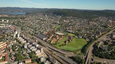Oslo, Norveç. İHA 'dan Oslo şehrine, yeni mahallelere ve yeni evlere giden güzel 4K panoramik hava videosu. Güneşli bir yaz gününde, dağların arka planında ve mavi gökyüzünde. (Seriler)