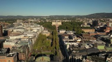 Oslo, Norveç. Kral Karl Johan Oslo 'nun Kraliyet Sarayı ve Heykeli' ne uçan insansız hava aracından güzel 4K panoramik video. Arka planda kale parkı, şehir ve dağlar (Seriler))