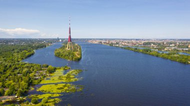 Riga, Latvija. Uçan İHA 'dan Riga Radyo ve Televizyon Kulesi Riga' ya güzel bir panoramik hava görüntüsü. Arka planda Zakusala, Daugava nehri ve Riga şehri güneşli bir yaz gününde. (Seriler)