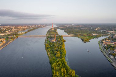 Riga, Latvija. Uçan İHA 'dan Riga Radyo ve Televizyon Kulesi Riga' ya güzel bir panoramik hava görüntüsü. Arka planda Zakusala, Daugava nehri ve Riga şehri güneşli bir yaz gününde. (Seriler)