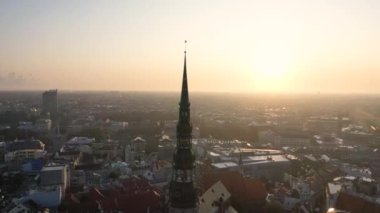 Riga, Letonya, Baltık. St. Peter Kilisesi 'ndeki ve Daugava Nehri' nin arka planındaki Eski Riga Kasabası 'ndaki insansız hava aracının güzel panoramik 4K videosu.