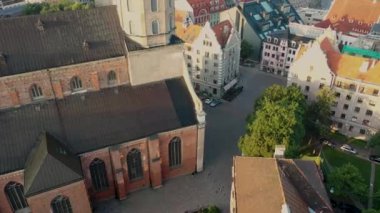 Riga, Letonya, Baltık. St. Peter Kilisesi 'ndeki ve Daugava Nehri' nin arka planındaki Eski Riga Kasabası 'ndaki insansız hava aracının güzel panoramik 4K videosu.