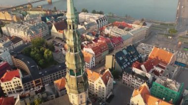 Riga, Letonya, Baltık. St. Peter Kilisesi 'ndeki ve Daugava Nehri' nin arka planındaki Eski Riga Kasabası 'ndaki insansız hava aracının güzel panoramik 4K videosu.