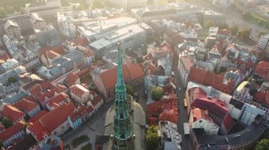 Riga, Letonya, Baltık. St. Peter Kilisesi 'ndeki ve Daugava Nehri' nin arka planındaki Eski Riga Kasabası 'ndaki insansız hava aracının güzel panoramik 4K videosu.