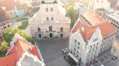 Riga, Letonya, Baltık. St. Peter Kilisesi 'ndeki ve Daugava Nehri' nin arka planındaki Eski Riga Kasabası 'ndaki insansız hava aracının güzel panoramik 4K videosu.