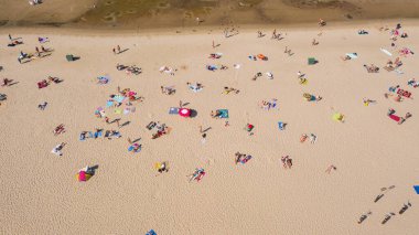 Dzintari, Jurmala, Letonya, Baltık. Sıcak ve güneşli bir yaz gününde Baltık Denizi 'nde güneşlenen ve yüzen insanlarla dolu Dzintari kumlu plajına uçan dron panoramiklerinden havadan çekilmiş bir fotoğraf. (Seriler)