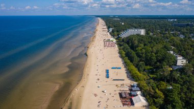 Majori, Jurmala, Letonya, Baltık. Sıcak ve güneşli bir yaz gününde, Baltık Denizi 'nde güneşlenen ve yüzen insanlarla dolu Majori kumsalına insansız hava aracı panoramik uçuşundan havadan çekilmiş bir fotoğraf. (Seriler)