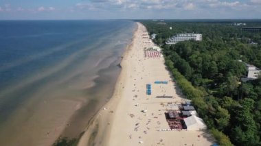 Jurmala, Majori, Letonya, Baltık. Sıcak ve güneşli bir yaz gününde, güneş banyosu yapan ve Baltık Denizi 'nde yüzen insanlarla dolu Majori kumlu plajına yapılan 4K' lık güzel panoramik video. (Seriler)