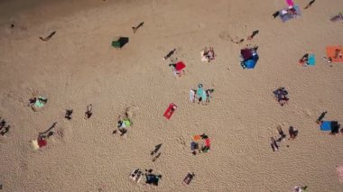 Jurmala, Dzintari, Letonya, Baltık. Sıcak ve güneşli bir yaz gününde Baltık Denizi 'nde güneşlenen ve yüzen insanlarla dolu Dzintari kumlu plajına yapılan 4K' lık güzel panoramik video. (Seriler)