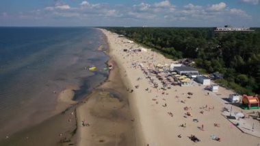 Jurmala, Dzintari, Letonya, Baltık. Sıcak ve güneşli bir yaz gününde Baltık Denizi 'nde güneşlenen ve yüzen insanlarla dolu Dzintari kumlu plajına yapılan 4K' lık güzel panoramik video. (Seriler)