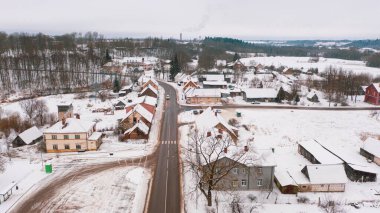 Akniste, Jekabpils, Letonya, Baltık. Kışın insansız hava aracından Akniste şehrine kadar uzanan güzel panoramik hava manzaralı fotoğraf. Küçük kasaba ve ormanlarda kar yağışlı bir kış manzarası. (seri)