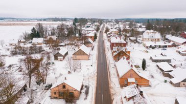 Akniste, Jekabpils, Letonya, Baltık. Kışın insansız hava aracından Akniste şehrine kadar uzanan güzel panoramik hava manzaralı fotoğraf. Küçük kasaba ve ormanlarda kar yağışlı bir kış manzarası. (seri)