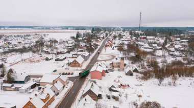 Akniste, Jekabpils, Letonya, Baltık. Kışın insansız hava aracından Akniste şehrine kadar uzanan güzel panoramik hava manzaralı fotoğraf. Küçük kasaba ve ormanlarda kar yağışlı bir kış manzarası. (seri)