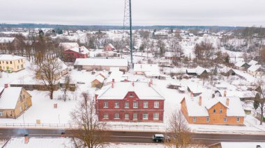 Akniste, Jekabpils, Letonya, Baltık. Kışın insansız hava aracından Akniste şehrine kadar uzanan güzel panoramik hava manzaralı fotoğraf. Küçük kasaba ve ormanlarda kar yağışlı bir kış manzarası. (seri)