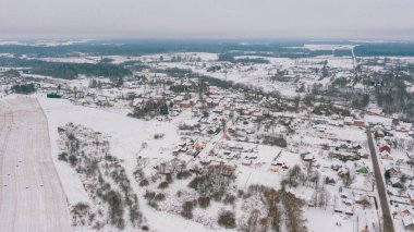 Akniste, Jekabpils, Letonya, Baltık. Kışın insansız hava aracından Akniste şehrine kadar uzanan güzel panoramik hava manzaralı fotoğraf. Küçük kasaba ve ormanlarda kar yağışlı bir kış manzarası. (seri)