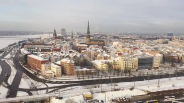 Riga, Letonya, Baltık. Güzel bir kış gününde Riga St. Peter Kilisesi ve Kubbesi 'nin arka planında İHA' dan Old Riga 'ya güzel panoramik hava 4K videosu açılıyor. (seri)