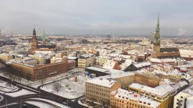 Riga, Letonya, Baltık. Güzel bir kış gününde Riga St. Peter Kilisesi ve Kubbesi 'nin arka planında İHA' dan Old Riga 'ya güzel panoramik hava 4K videosu açılıyor. (seri)