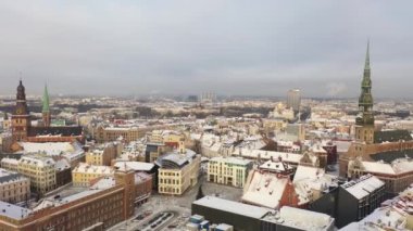 Riga, Letonya, Baltık. Güzel bir kış gününde Riga St. Peter Kilisesi ve Kubbesi 'nin arka planında İHA' dan Old Riga 'ya güzel panoramik hava 4K videosu açılıyor. (seri)