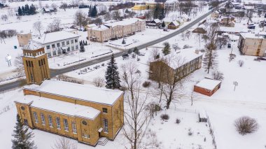Akniste, Jekabpils, Letonya, Baltık. Karlı bir kış gününde, beyaz kar altında, İHA 'dan Akniste Katolik Kilisesi' ne güzel panoramik hava manzaralı bir fotoğraf. Mimari Miras. (seri)