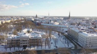 Riga, Letonya, Baltık. Güzel bir kış gününde Riga St. Peter Kilisesi ve Kubbesi 'nin arka planında İHA' dan Old Riga 'ya güzel panoramik hava 4K videosu açılıyor. (seri)