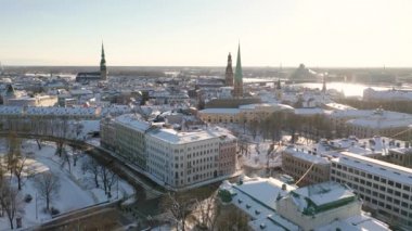 Riga, Letonya, Baltık. Güzel bir kış gününde Riga St. Peter Kilisesi ve Kubbesi 'nin arka planında İHA' dan Old Riga 'ya güzel panoramik hava 4K videosu açılıyor. (seri)