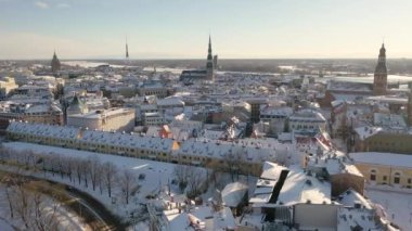 Riga, Letonya, Baltık. Güzel bir kış gününde Riga St. Peter Kilisesi ve Kubbesi 'nin arka planında İHA' dan Old Riga 'ya güzel panoramik hava 4K videosu açılıyor. (seri)