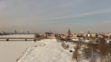 Riga, Letonya, Baltık. Uçan İHA 'dan hareket eden makinelerle Ada Köprüsü' ne, kış günbatımından güzel panoramik 4K video. (Seriler)