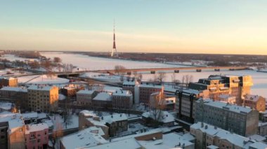 Riga, Letonya, Baltık. Güneşli bir kış gününde Daugava Nehri 'nin arka planında ve şehir merkezinde Ada Köprüsü' nde insansız hava aracı uçururken çekilen güzel panoramik 4K videosu. (Seriler)