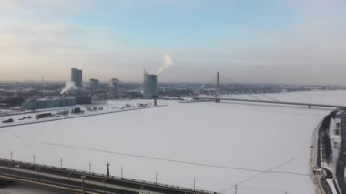 Riga, Letonya, Baltık. Stone 'da insansız hava aracı uçururken çekilmiş güzel panoramik 4K video ve güzel güneşli bir kış gününde Daugava Nehri' nin arka planında ve şehir merkezinde kablolu köprü. (Seriler)