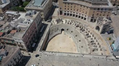 Lecce, Puglia, İtalya. Güzel panoramik hava 4K video. İHA 'dan Roma Amfitiyatrosuna, Arena Lecce' ye. Tarihi şehir merkezi, Maria Santissima Assunta Katedrali, güzel bir yaz gününde..
