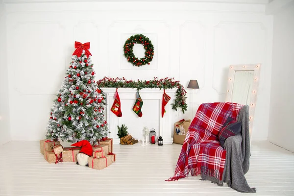 the white light interior features a new year\'s location with a spruce tree, a fireplace and a chair with a warm blanket.