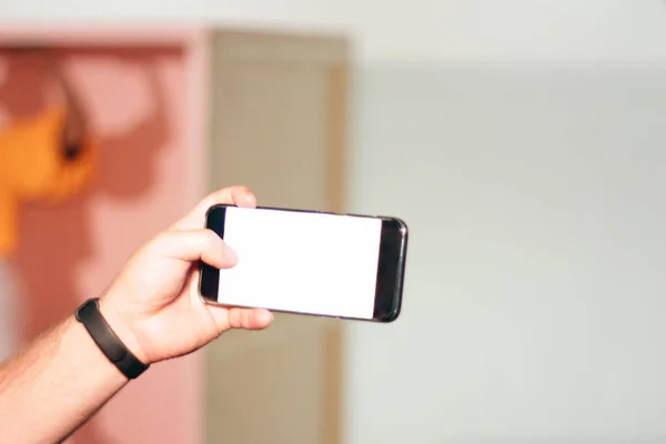 Telefon Mans Hand Bakgrunden Ljus Vägg — Stockfoto