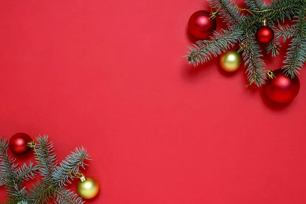 Noel çerçevesi köknar dallarından yapılmış, kırmızı zemin üzerinde noel süsleri ve metin için fotokopi alanı. Noel ve Yeni Yıl kavramı.