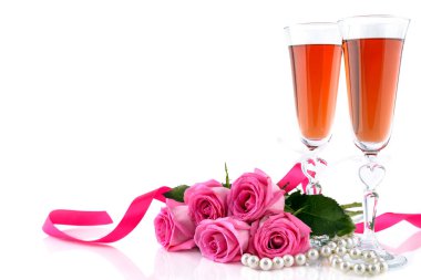 Sevgililer Günü konsepti. İki kadeh şarap, kırmızı güller ve beyaz arkaplanda yazı için fotokopi alanı olan bir dizi inci. Seçici odak.