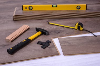 Döşeme, çekiç, çekiç, çekiç, uzay boşlukları, ruhsal seviye alet ve metreyi yerleştirmek için ekipman veya araçlar. Seçici odak.